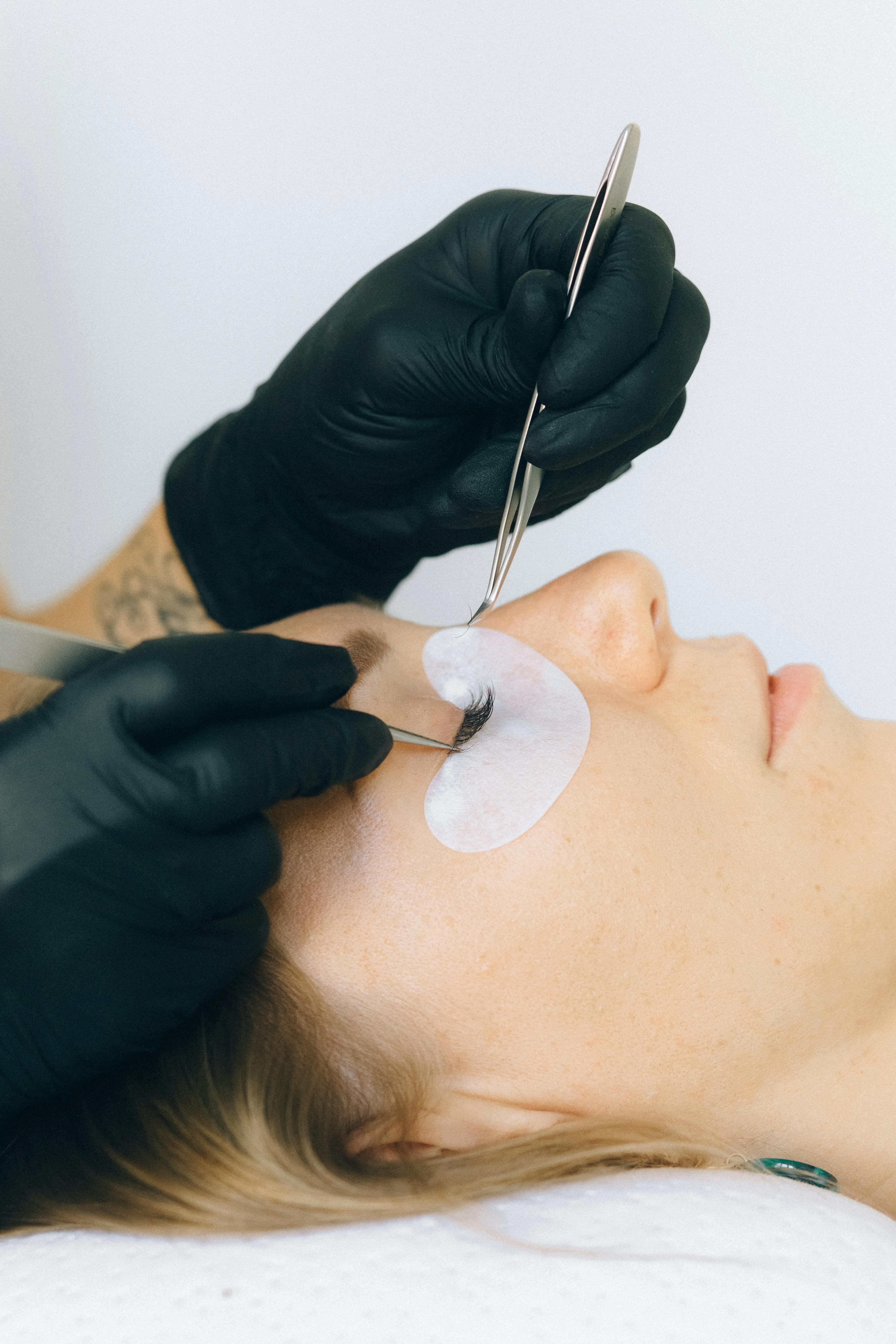 Wimpernverlängerung mit Pinzette und Augenpads